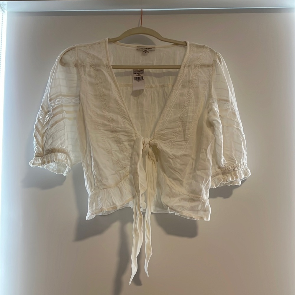 Cute white top that can also be used as a cover up with flower detail!